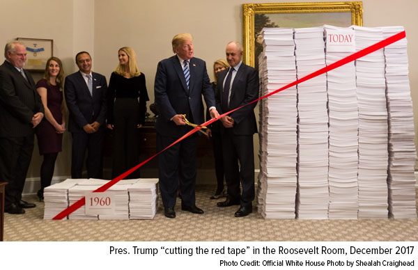 Pres. Trump “cutting the red tape” in the Roosevelt Room, December 2017