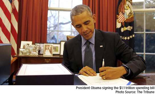 President Obama signing the $1.1 trillion spending bill 